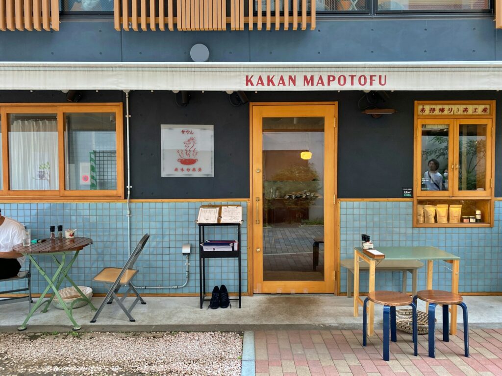 a man sitting at a table outside of a restaurant