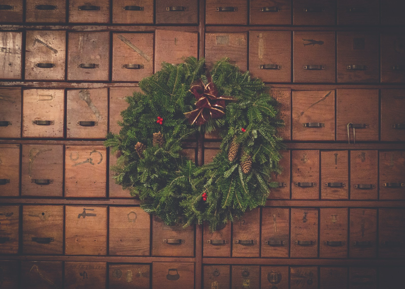 green and brown pinecone Christmas wreath on wooden drawers